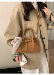 Brown faux suede doctor bag shown with a plush rabbit charm and crossbody strap