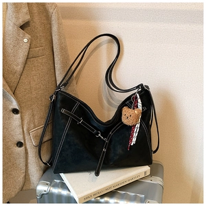 Detail view of large black vintage tote bag with white stitching and bear charm