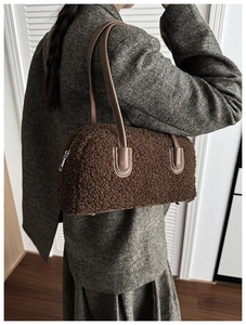 Gros plan d'un sac à main en peluche marron foncé avec bandoulières en cuir premium