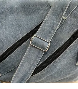 Detail of blue denim fabric texture with silver metal buckle and black zipper