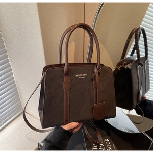 Detailansicht der dunkelbraunen Vintage-Tasche mit goldenem Logo und mattem Leder-Finish