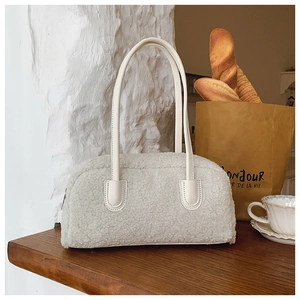 Détail du sac à main en laine d'agneau blanche avec poignées en cuir et fermeture éclair