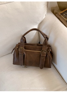 Gros plan détaillé d'un sac Boston en cuir PU marron foncé avec boucles en bronze antique