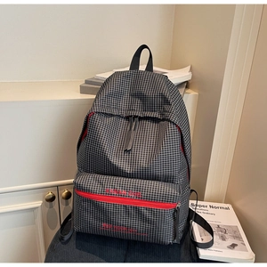 Close-up of a large black and white checkered backpack with red zipper detail and logo