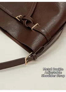 Détail du sac en cuir marron foncé avec boucle dorée et bandoulière réglable pratique