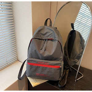 Close-up of black and white plaid backpack with striking red zipper and brand logo