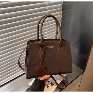 Detailansicht der dunkelbraunen Vintage-Tasche mit goldener Schrift und Trageriemen