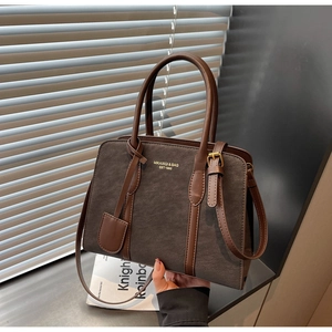 Nahaufnahme der Vintage-Tragetasche mit matter Lederstruktur und Markenschriftzug