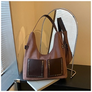 Detailansicht der braunen Wildledertasche mit silbernen Nieten und zwei Fronttaschen