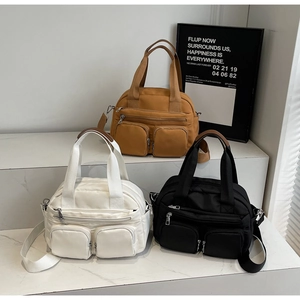 Three corduroy crossbody bags in caramel, white, and black with double zipper pockets