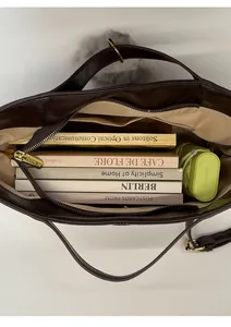 Interior view showing the large capacity of the tote bag holding books and an umbrella