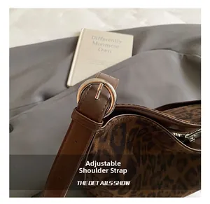 Detailed close-up of adjustable strap with silver buckle on leopard print shoulder bag