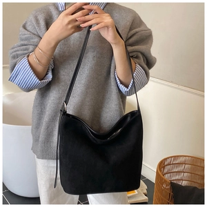 Detail of a black faux suede large capacity shoulder tote bag shown in a lifestyle mirror photo