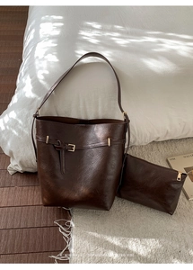 Dettaglio set borsa a secchiello in pelle marrone caffè con pochette e dettagli dorati