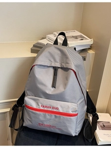 Minimalist grey plaid backpack for students with vibrant red zippers and letter print