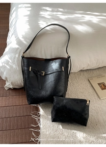 Dettaglio del set borsa tote in pelle martellata nera con finiture dorate lucide