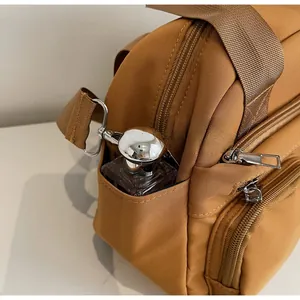 Detail of durable khaki crossbody bag showing multiple pockets and nylon fabric texture