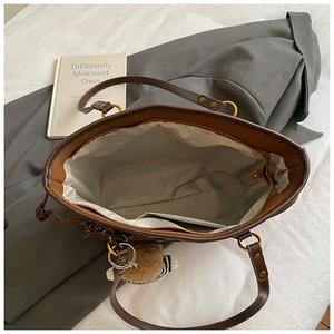 Détail intérieur du grand sac cabas marron montrant la poche zippée et l'espace