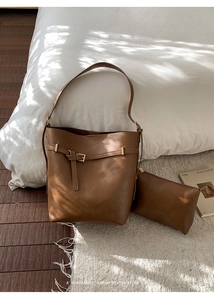 Dettaglio del set borsa a secchiello in pelle marrone retrò con pochette coordinata