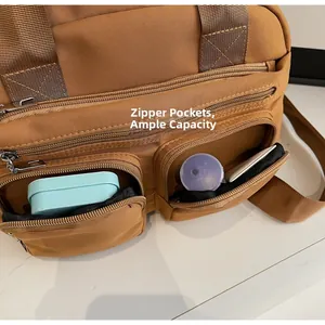 Close-up of brown nylon messenger bag showing double front zipper pockets for storage