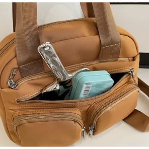 Detail of the brown multi-pocket nylon handbag showing spacious zipper compartment and texture