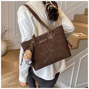 Détail du grand sac cabas en cuir marron foncé avec pendentif ours et métal doré