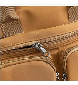 Detail of smooth silver metal zipper on camel nylon crossbody bag with durable texture