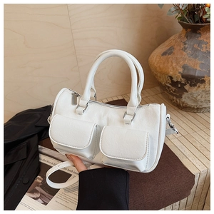 Detailed view of white multi-pocket handbag with silver hardware and adjustable strap