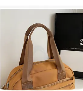 Close-up of durable brown canvas handbag featuring reinforced leather handle detailing