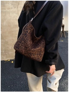 Detail of leopard print tote featuring suede texture and adjustable leather strap
