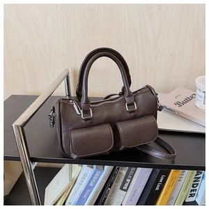 Detailed macro view of deep brown vintage boston bag with twin front flap pockets