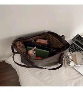 Interno spazioso della borsa tote marrone scuro con fodera a righe e tasca con cerniera