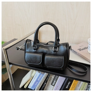 Detail of vintage black faux leather handbag with silver zippers and front flap pockets