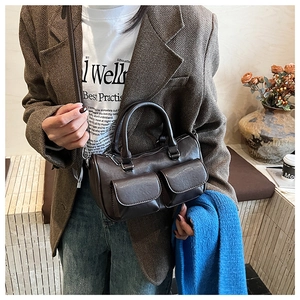 Detail of vintage dark brown faux leather pillow bag with double front flap pockets