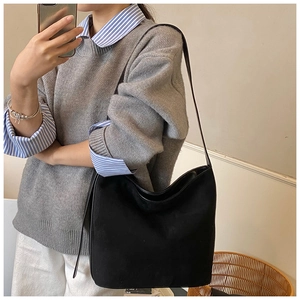 Close-up of minimalist black matte leather hobo bag showing texture and crescent shape