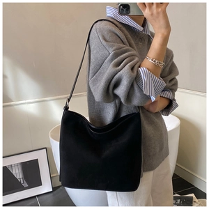 Minimalist black oversized tote bag shown on shoulder in a stylish mirror selfie