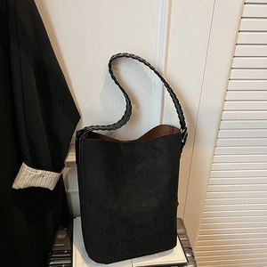Detail of the black suede tote bag with a sophisticated braided shoulder strap design