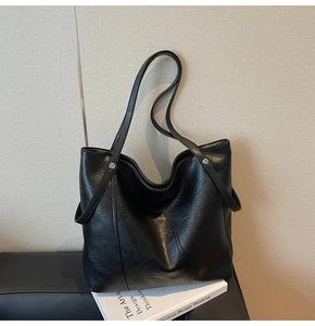 Dettaglio della borsa tote nera con cuciture verticali e borchie in metallo argento