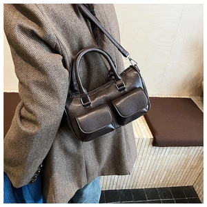 Detailed view of deep brown vintage faux leather handbag worn on person side profile