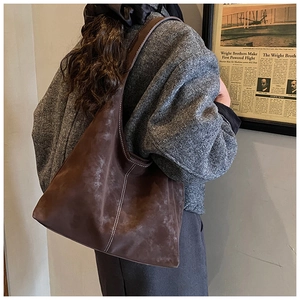 Close-up of brown suede tote bag with white contrast stitching for a vintage casual look