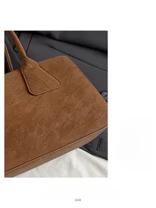Gros plan sur la texture du cuir grainé marron caramel et les coutures de la anse