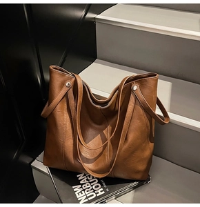 Borsa tote marrone sulle scale che mostra grande capacità e dettagli in morbida pelle