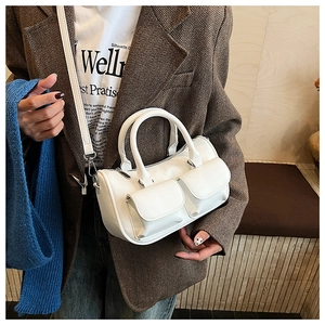 Detail view of a white multi-pocket handbag with pebbled leather and silver hardware accents