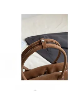 Gros plan sur le cuir marron foncé grainé et les finitions métalliques argentées de luxe