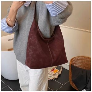 Detail of burgundy suede tote bag with white contrast stitching and soft matte texture