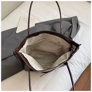 Macro view of interior storage and silver rivets on dark brown leather tote bag