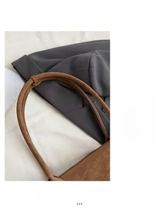 Détail d'un sac bandoulière vintage marron avec sangle cylindrique et coutures précises
