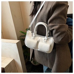 Detailed view of white leather handbag styled with a brown herringbone blazer jacket