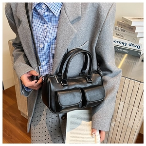 Detail of black matte leather boston bag with double front flap pockets and silver hardware