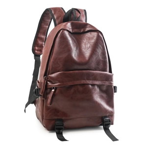 Detail view of large brown soft leather backpack with litchi texture and buckle strap